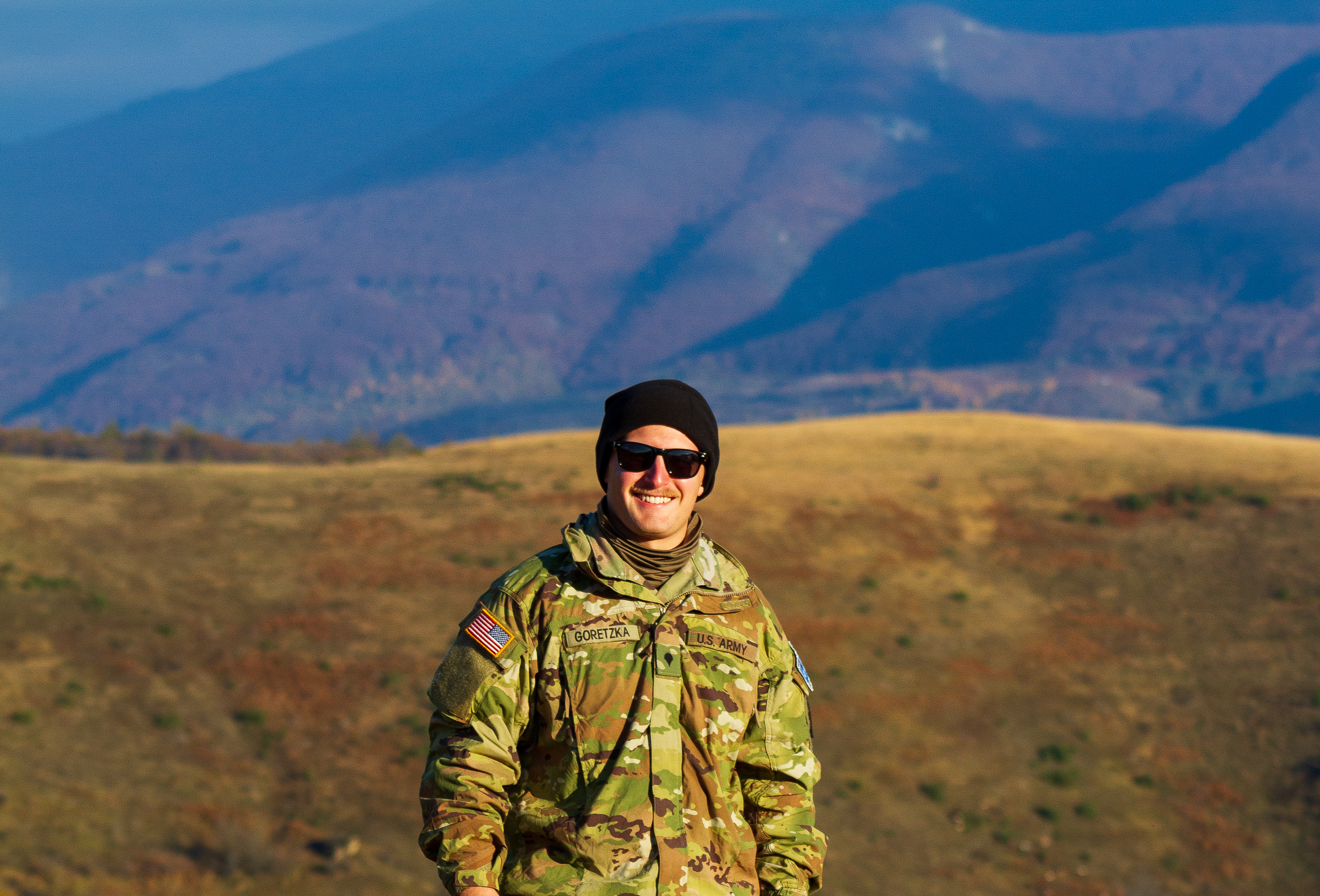 Drew in military uniform in Kosovar mountains
